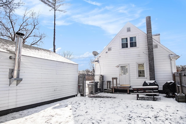 view of snow covered back of property