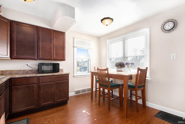 kitchen featuring dark wood-type flooring and dark brown cabinetry