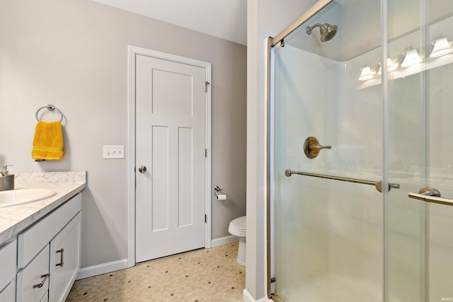 bathroom with vanity, a shower with shower door, and toilet