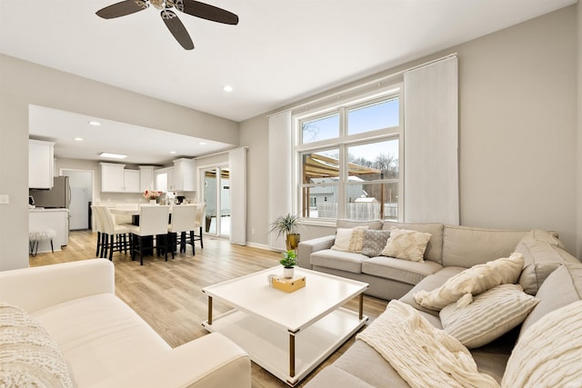 living room featuring light wood-type flooring and ceiling fan