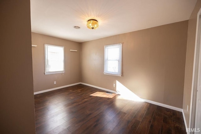 unfurnished room with plenty of natural light and dark hardwood / wood-style flooring