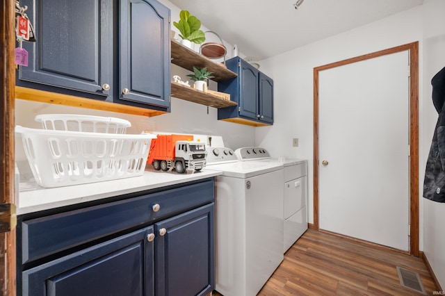 laundry area featuring cabinets, dark hardwood / wood-style floors, and washer and dryer