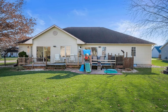 rear view of house featuring a wooden deck and a yard