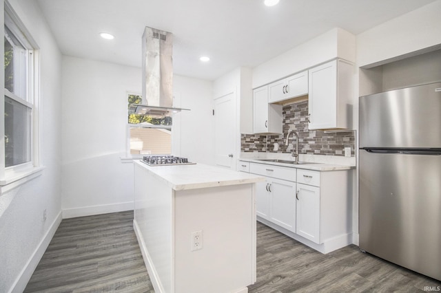 kitchen featuring white cabinets, appliances with stainless steel finishes, wood-type flooring, sink, and island range hood