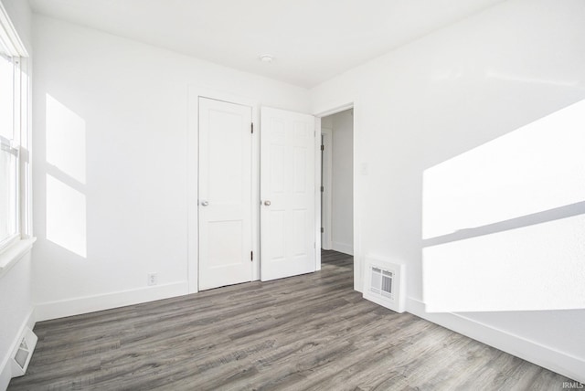 unfurnished room with plenty of natural light and dark hardwood / wood-style floors