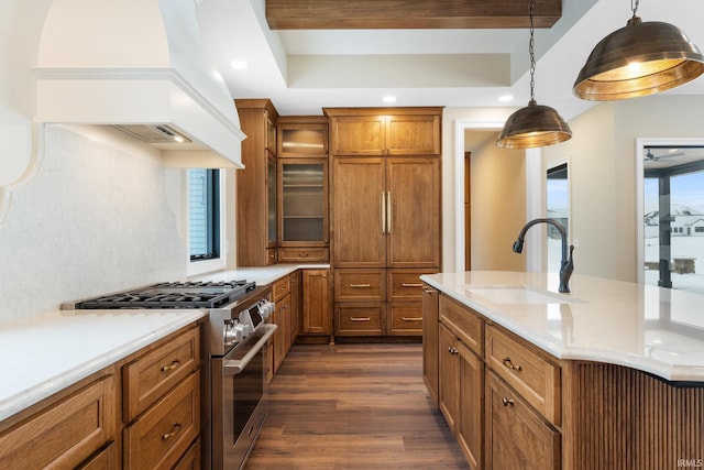 kitchen with pendant lighting, sink, premium range hood, dark wood-type flooring, and gas stove