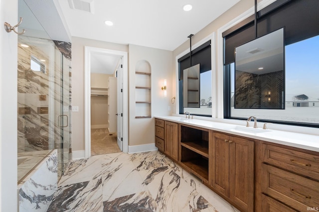 bathroom featuring vanity, a shower with shower door, and built in features