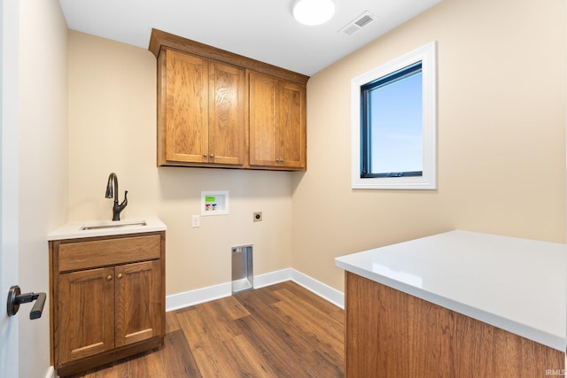 laundry area featuring electric dryer hookup, sink, dark wood-type flooring, cabinets, and washer hookup