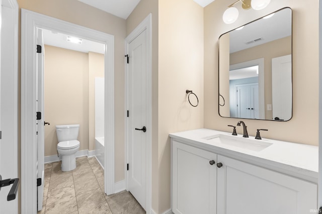 bathroom with a washtub, toilet, and vanity