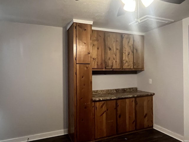 bar featuring ceiling fan and dark hardwood / wood-style flooring