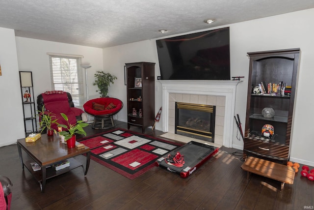 living room featuring hardwood / wood-style flooring, a textured ceiling, and a fireplace