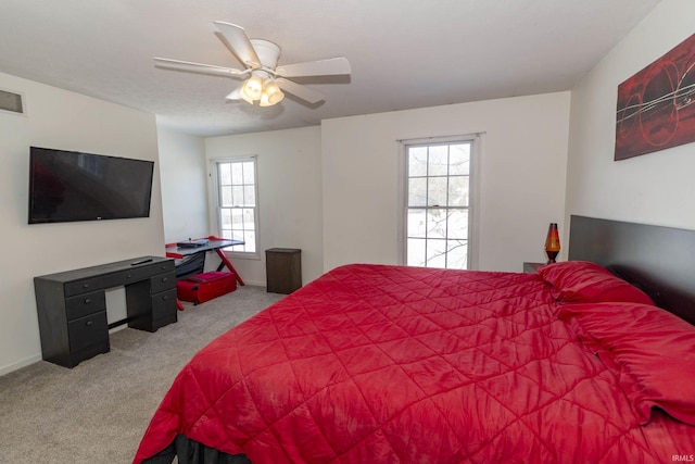 carpeted bedroom featuring ceiling fan and multiple windows