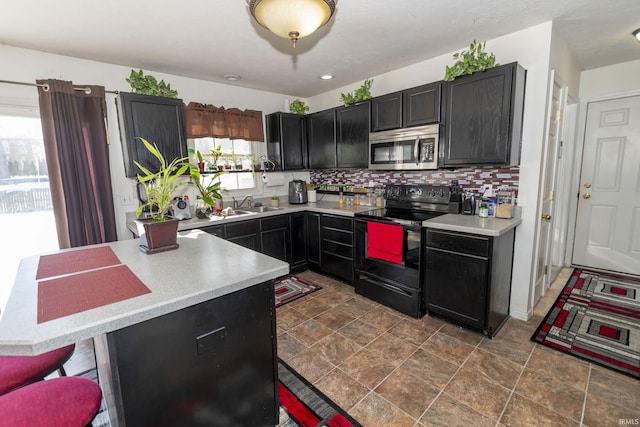 kitchen featuring sink, electric range, and tasteful backsplash