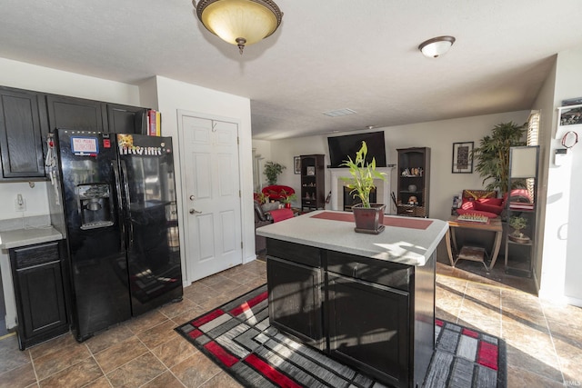 kitchen featuring a kitchen island and black fridge with ice dispenser