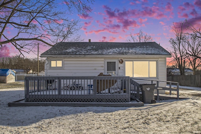 back house at dusk with a wooden deck