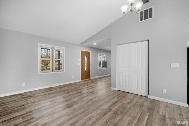 interior space with light hardwood / wood-style floors, high vaulted ceiling, and a notable chandelier