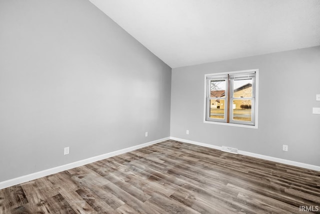 unfurnished room featuring hardwood / wood-style floors and lofted ceiling