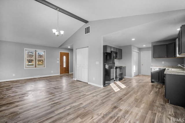 kitchen with hardwood / wood-style flooring, black refrigerator, a chandelier, and vaulted ceiling with beams