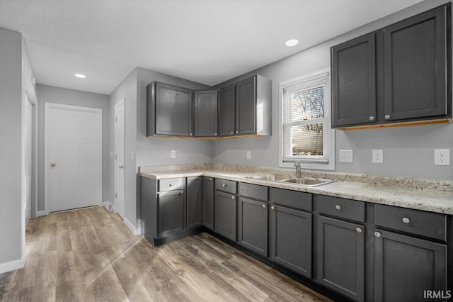 kitchen featuring sink, hardwood / wood-style floors, and gray cabinetry