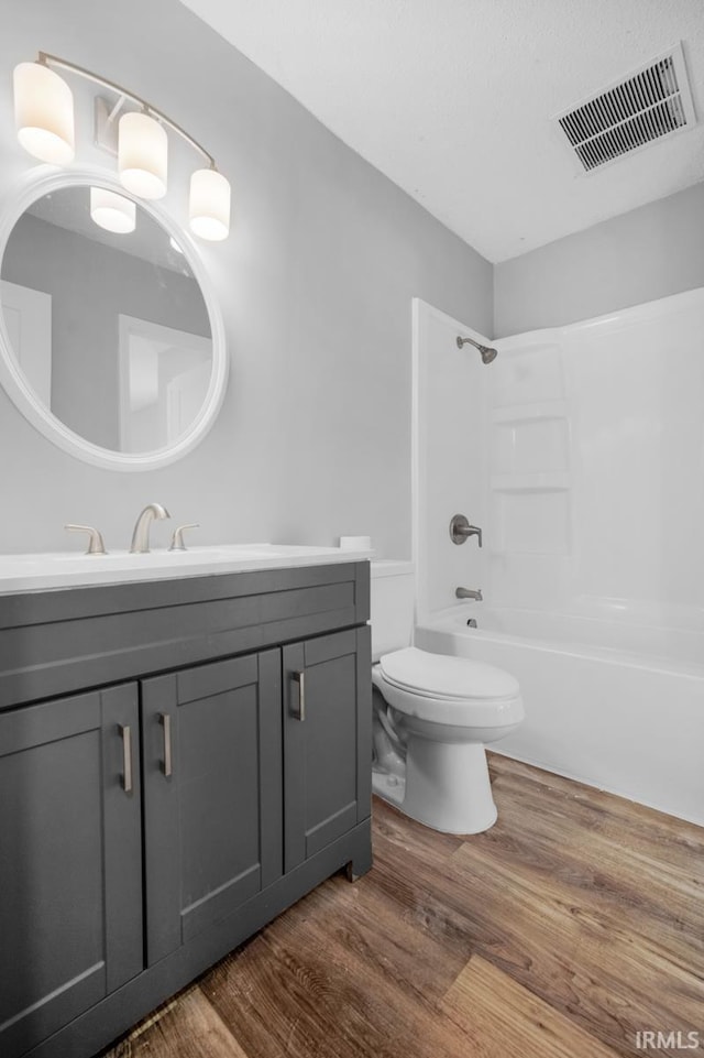 full bathroom with hardwood / wood-style flooring, shower / bath combination, toilet, and vanity