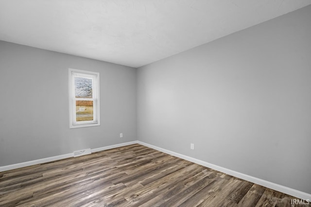 unfurnished room with dark hardwood / wood-style flooring