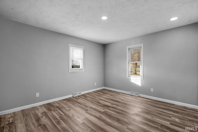 unfurnished room with wood-type flooring