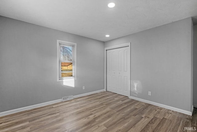 unfurnished bedroom featuring light wood-type flooring and a closet