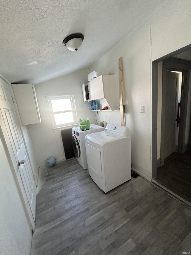 laundry area featuring a textured ceiling, washer and clothes dryer, and dark hardwood / wood-style flooring