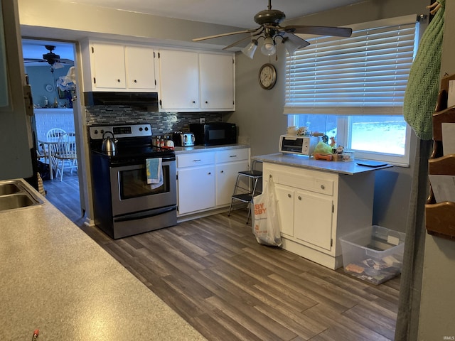 kitchen with dark hardwood / wood-style flooring, backsplash, white cabinets, and stainless steel electric range oven