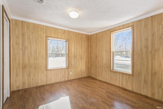 unfurnished room with hardwood / wood-style flooring, crown molding, and a textured ceiling