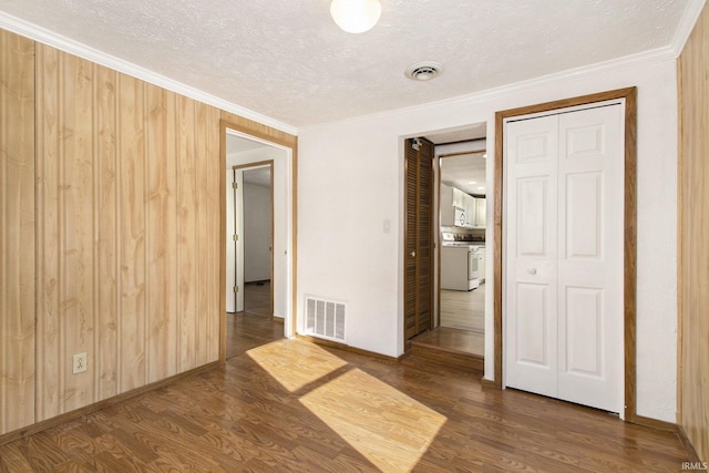 unfurnished bedroom with a textured ceiling, dark hardwood / wood-style flooring, crown molding, and a closet