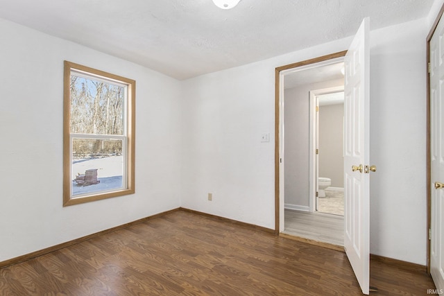 unfurnished bedroom featuring dark wood-type flooring and a textured ceiling