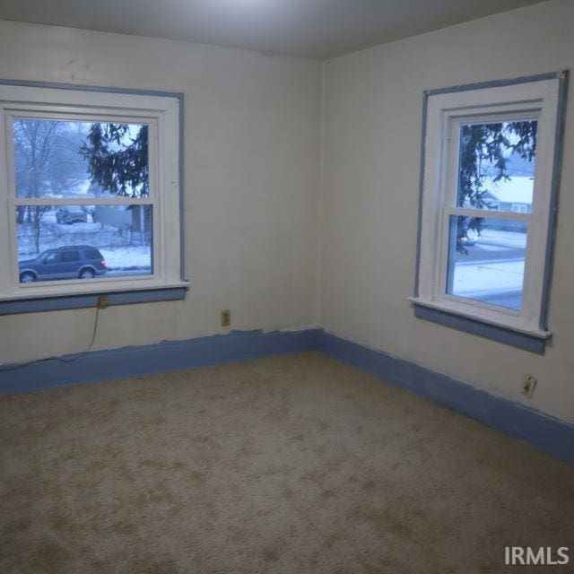 unfurnished room with plenty of natural light and carpet