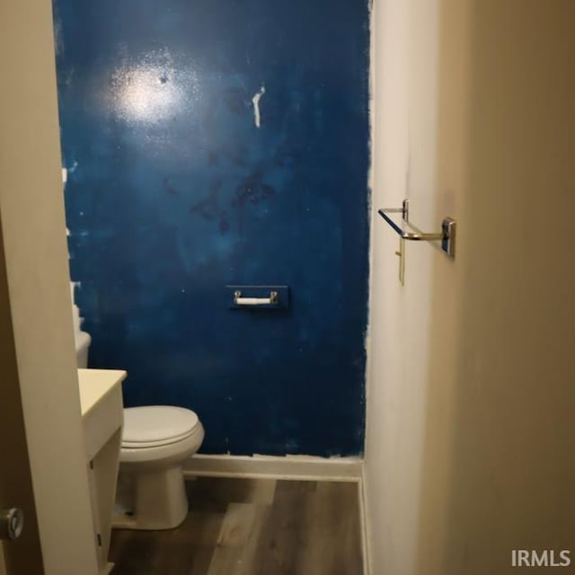 bathroom with vanity, toilet, and hardwood / wood-style flooring