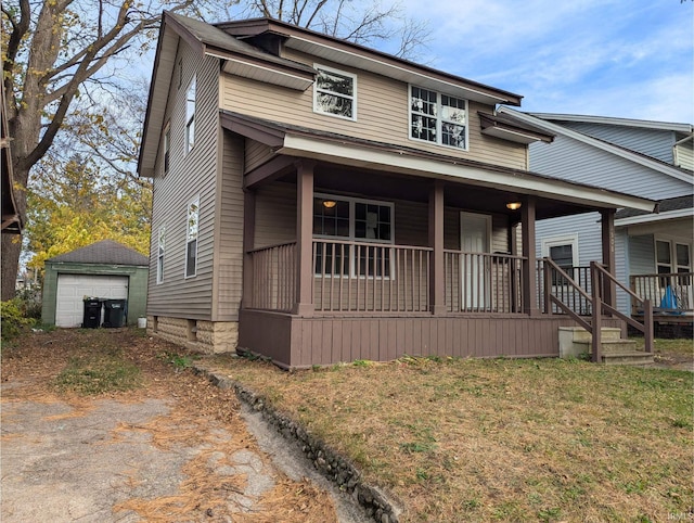 view of front of property featuring a garage, a front yard, an outbuilding, and a porch