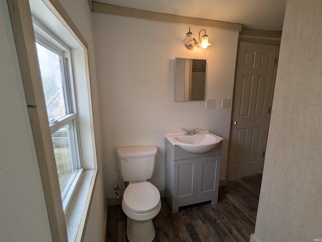 bathroom with hardwood / wood-style flooring, toilet, and vanity