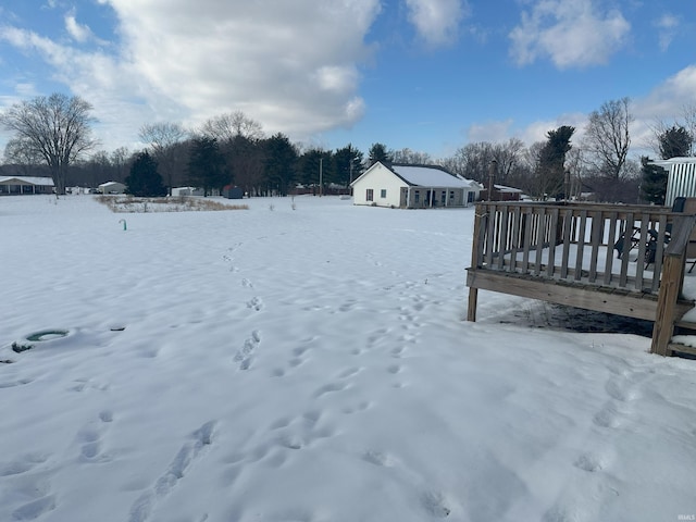 yard layered in snow with a deck