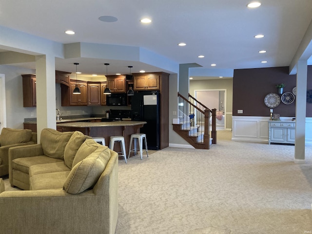 living area with light carpet, stairway, recessed lighting, and wainscoting