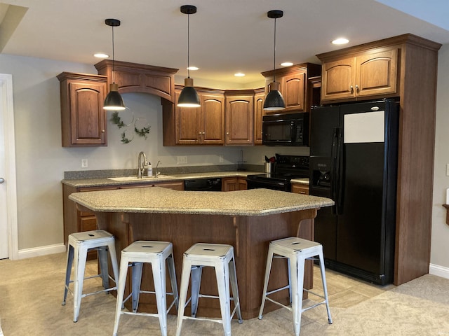 kitchen featuring black appliances, hanging light fixtures, a kitchen breakfast bar, sink, and light colored carpet