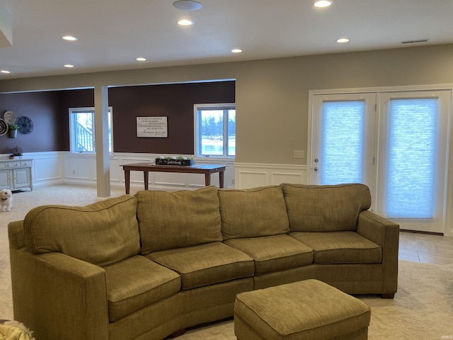 living area with visible vents, a wainscoted wall, recessed lighting, a decorative wall, and light colored carpet