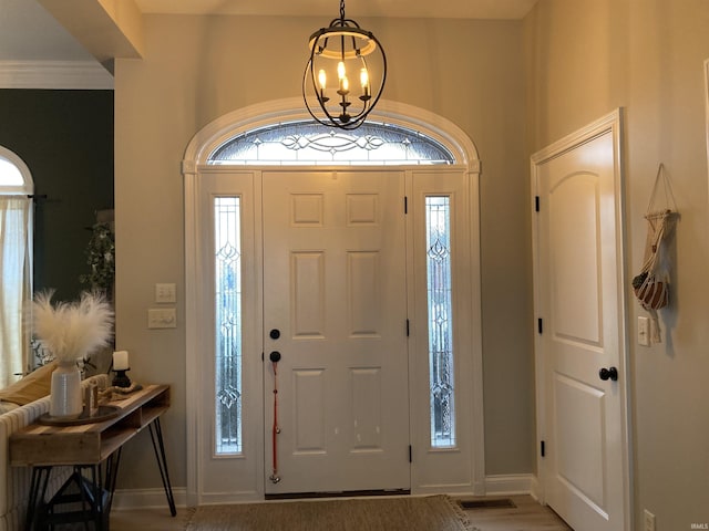 foyer entrance featuring baseboards and an inviting chandelier