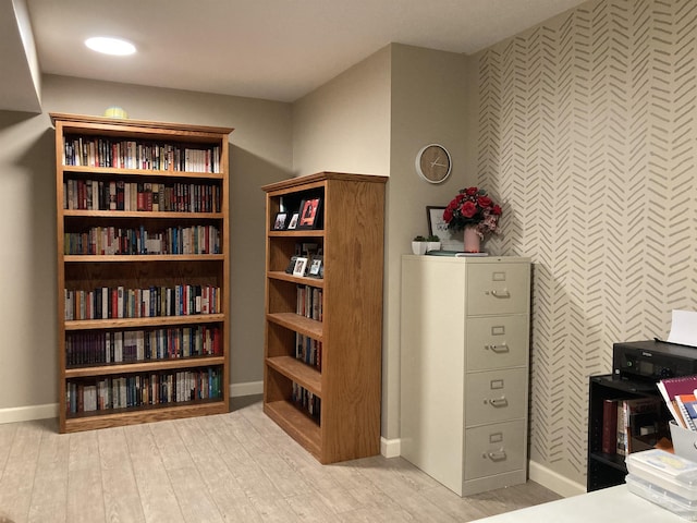 interior space with an accent wall, wood finished floors, and baseboards