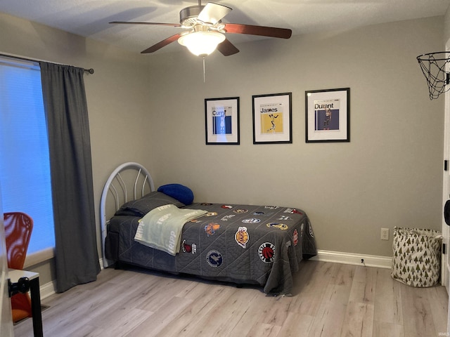 bedroom with ceiling fan, baseboards, and wood finished floors