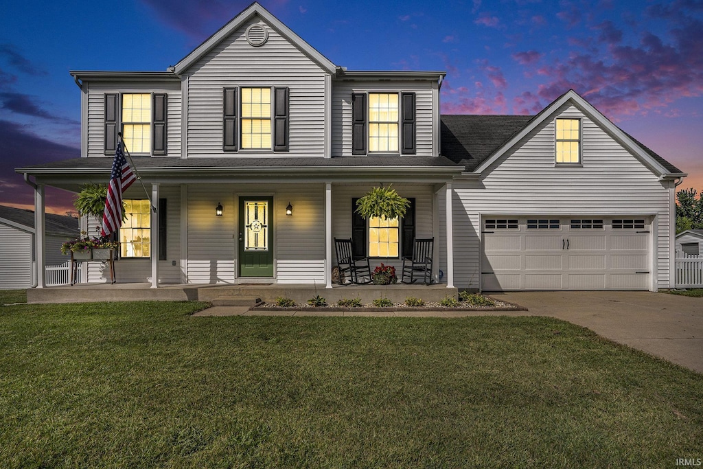 view of front of house featuring a porch, a garage, and a lawn