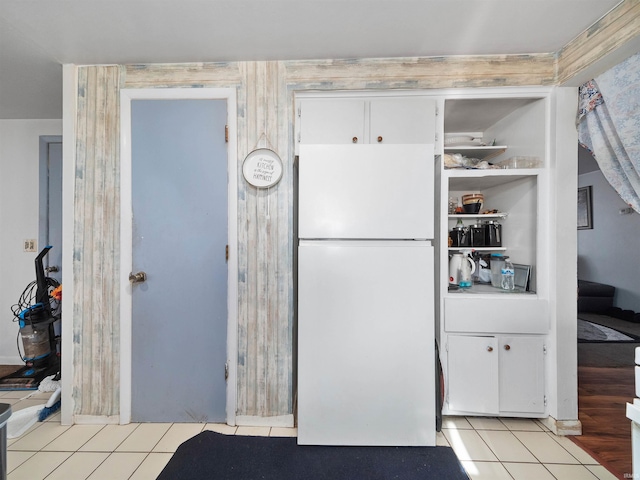 kitchen with light tile patterned floors, white cabinets, and white refrigerator