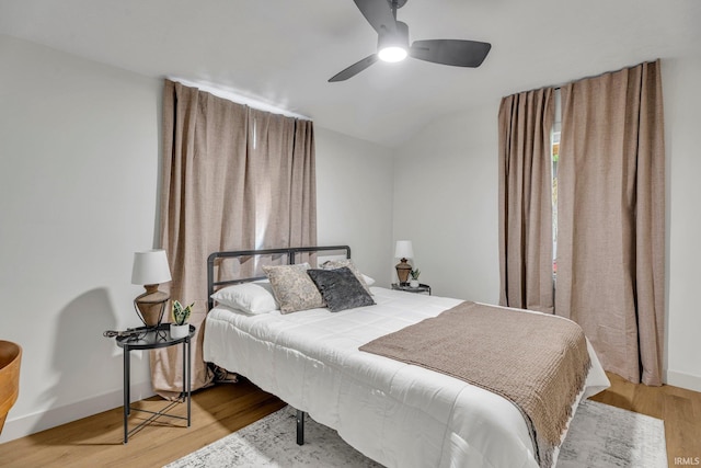 bedroom featuring ceiling fan, hardwood / wood-style flooring, and vaulted ceiling