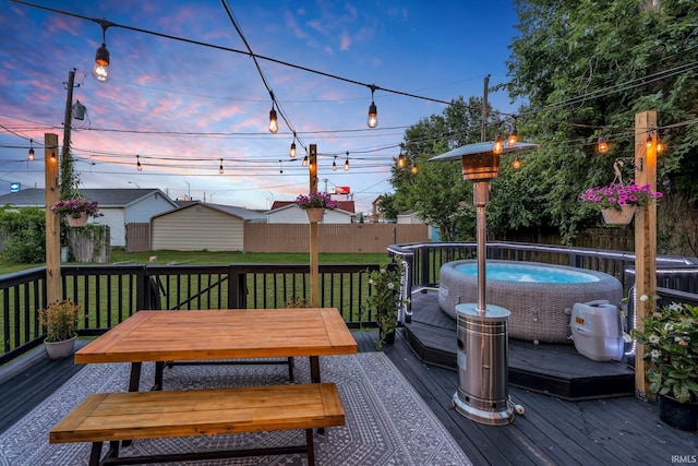 deck at dusk with a swimming pool and a yard