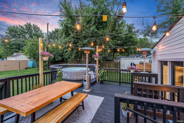 deck at dusk with a yard and a swimming pool