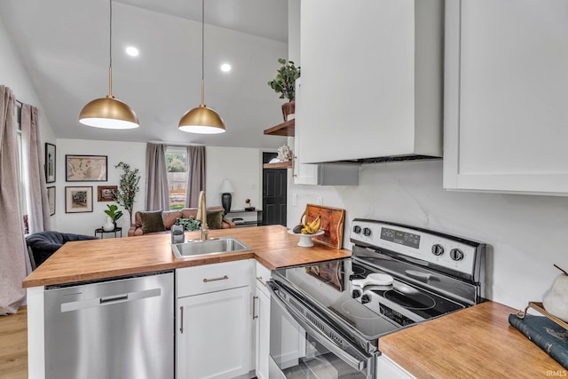 kitchen featuring appliances with stainless steel finishes, white cabinetry, sink, kitchen peninsula, and pendant lighting