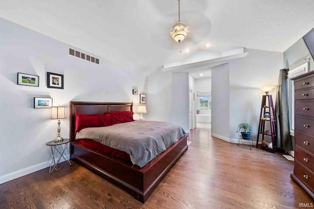 bedroom featuring ceiling fan, ensuite bathroom, vaulted ceiling, and dark wood-type flooring